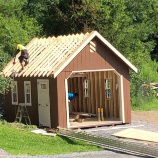 This is a speciality shed where the bottom come already prebuilt and the roof is built on site. The roof materials come inside the shed, the crew then arrives and finishes it on site.