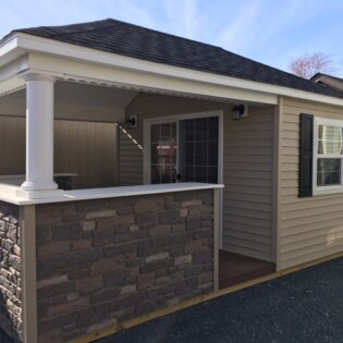 12x24 Pool house bar unit, with 6' sliding glass door, round post, stone facade, hip roof.